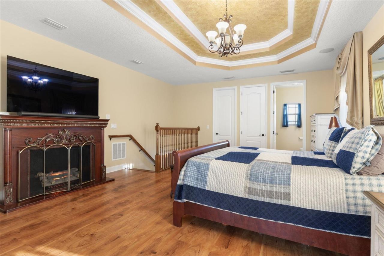 Photo 19 of 20: Warm wood-look flooring, an elegant tray ceiling and generous living space create a comfortable setting for a private upstairs retreat.