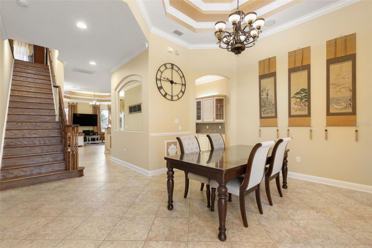 Photo 15 of 20: A beautifully appointed dining room with an elegant tray ceiling, decorative chandelier and architectural details that create a memorable setting for gatherings.