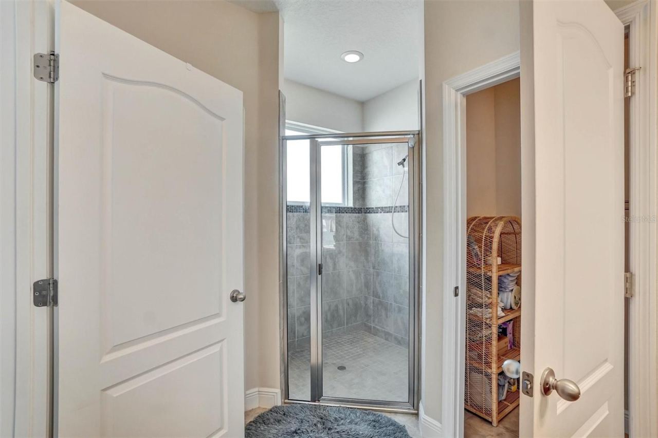 Photo 15 of 20: Walk-In ShowerSpacious shower with tiled walls, glass doors, and built-in lighting.