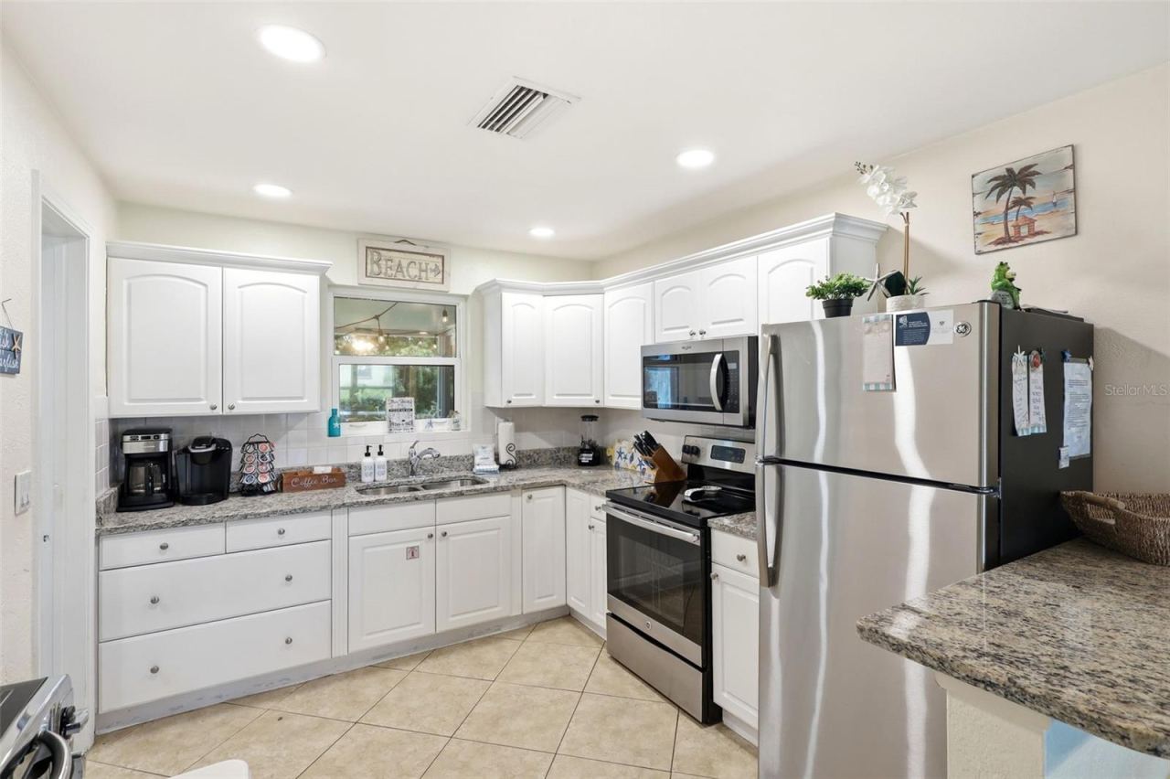 Photo 4 of 20: Kitchen. White cabinets, granite, and stainless appliances