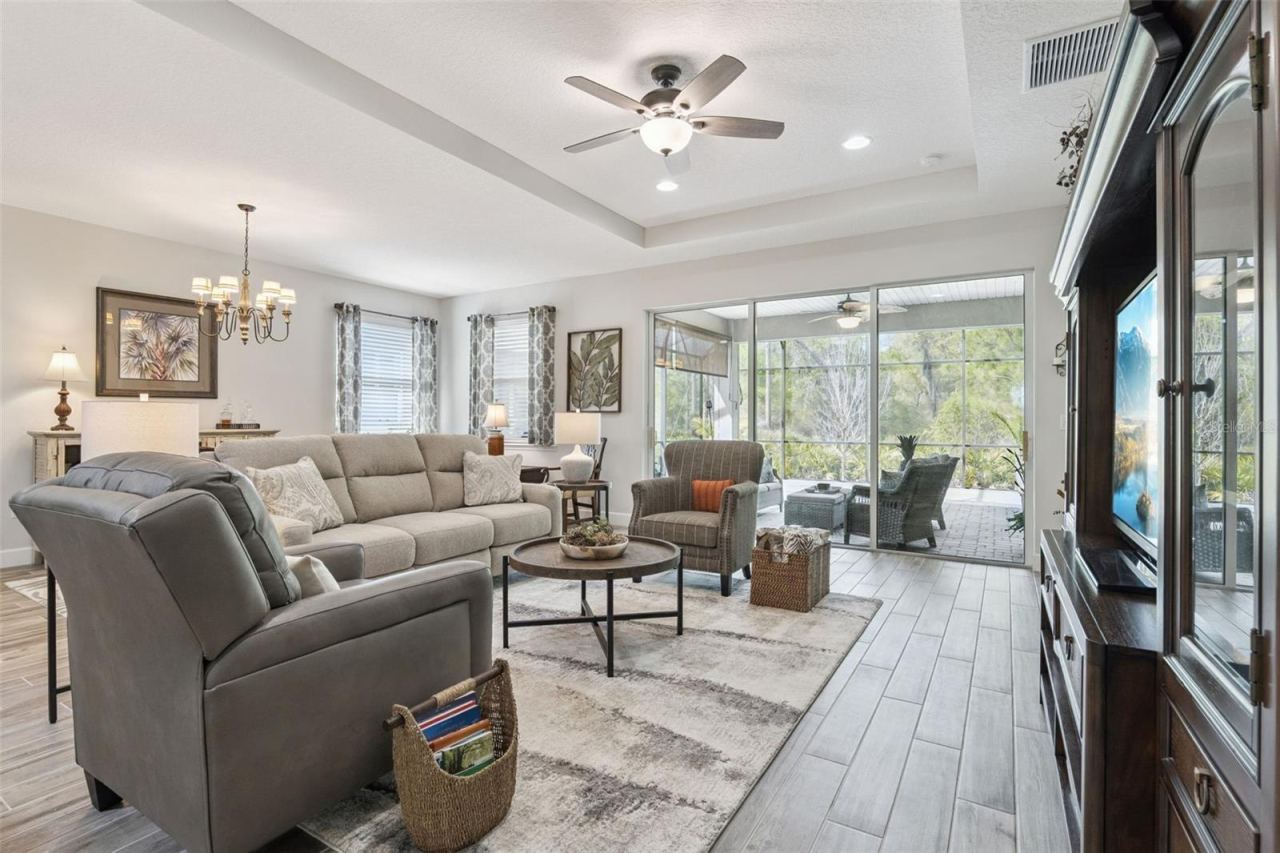 Photo 7 of 20: Spacious Great Room plan, wonderful for entertaining.Triple sliders take you out to the 26'x28' screened lanai, overlooking a wooded view