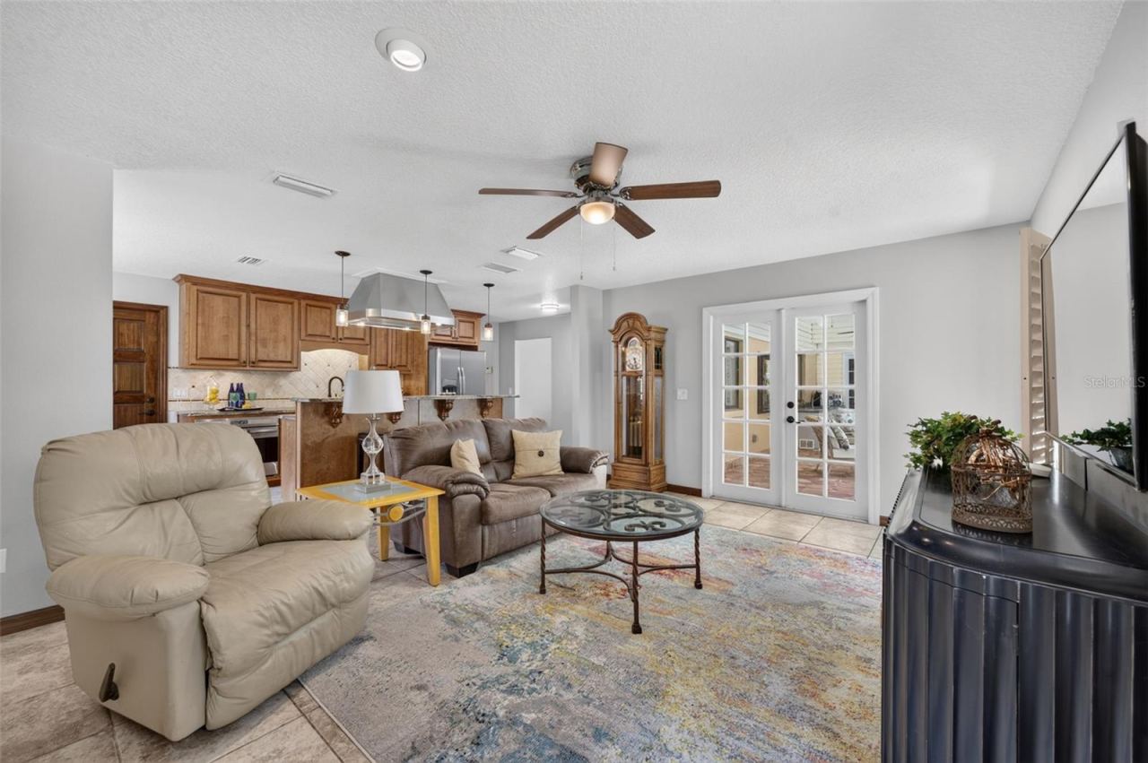 Photo 7 of 20: Open concept Kitchen and Fireplaced Family Room. French Doors to the POOL!