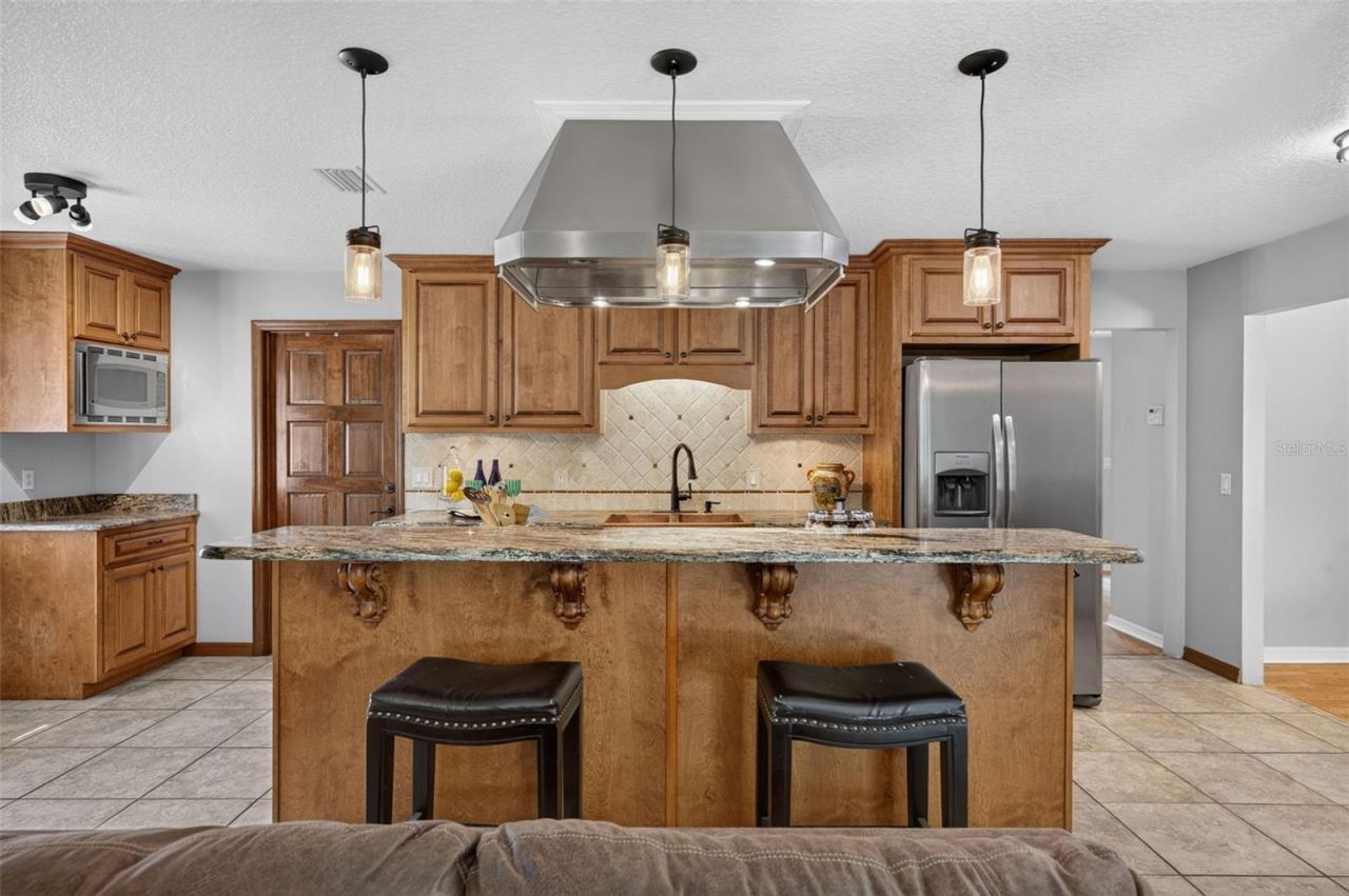 Photo 11 of 20: Granite topped kitchen cabinets with Breakfast Bar