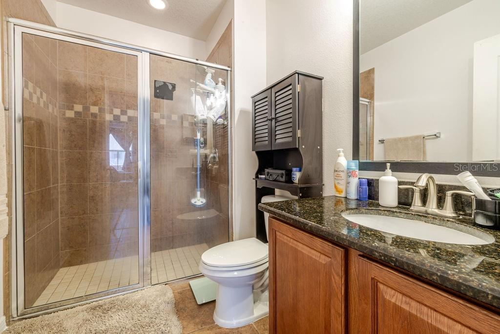 Photo 20 of 20: Ensuite bathroom to primary bedroom with tile shower and granite countertops