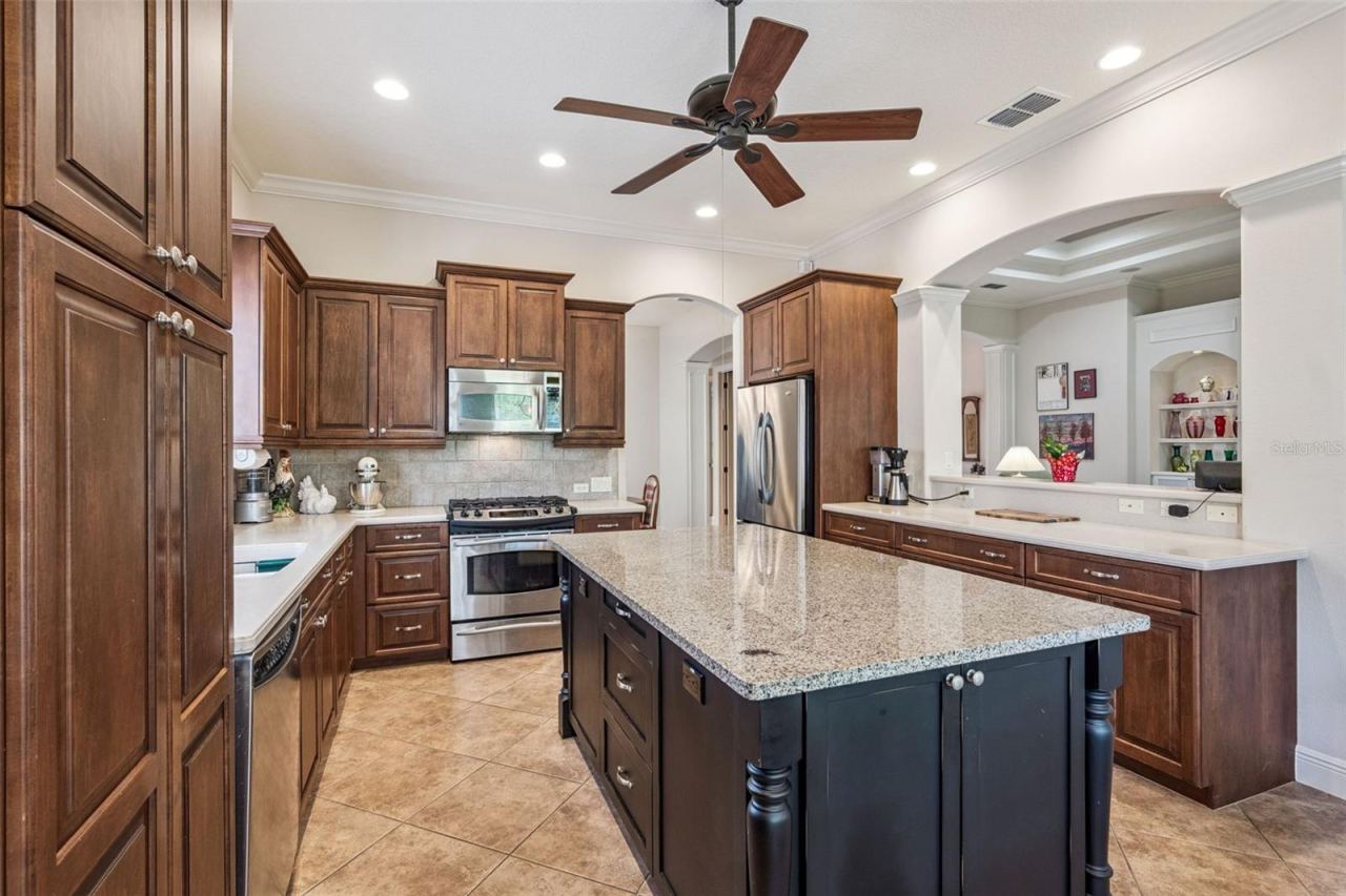 Photo 11 of 20: 14' x 12'6" Kitchen w/ center island, slide-out shelving, under cabinet lighting & stainless steel appliances