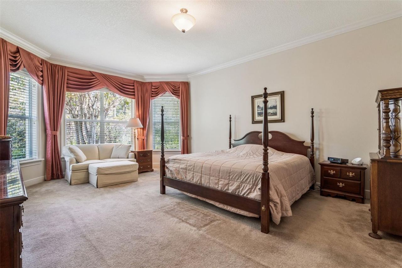 Photo 20 of 20: 15' x 20' Primary Bedroom w/ crown molding & a conservation area view
