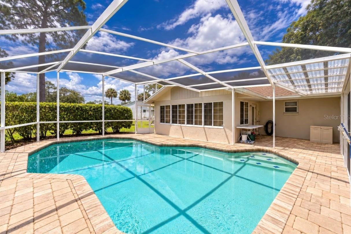 Photo 4 of 20: Spacious screened lanai showcasing an in-ground swimming pool, brick pavers, and direct access to the home.