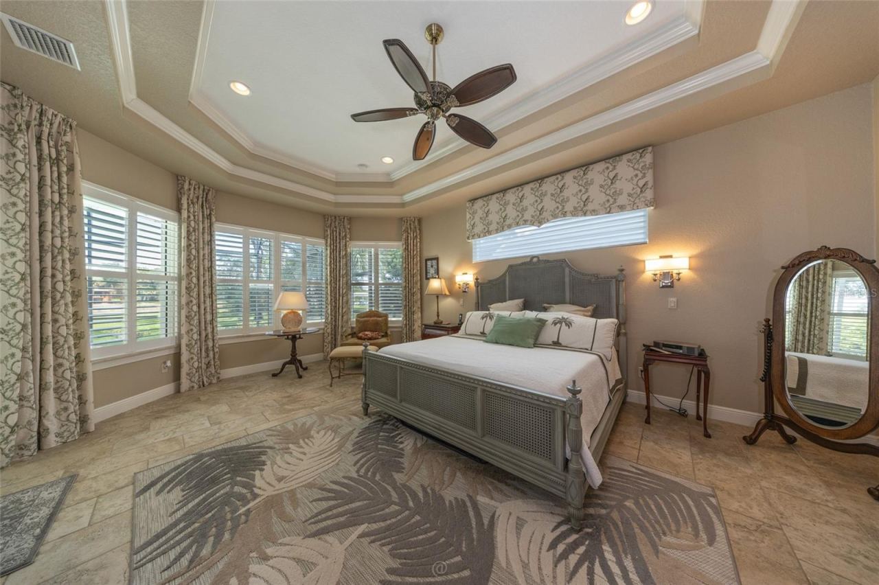 Photo 14 of 20: Wake Up To Pristine ICW Views And Radiant Morning Light. This Luxurious Primary Suite Features An Elegant Tray Ceiling, Plantation Shutters, And Coastal-Inspired Design.