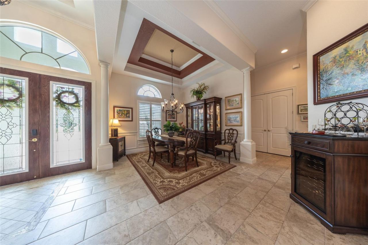 Photo 9 of 20: Light-Filled Entryway Opens Into A Formal Dining Area Complete With Tray Ceilings, Tiled Flooring, And Architectural Column Accents.